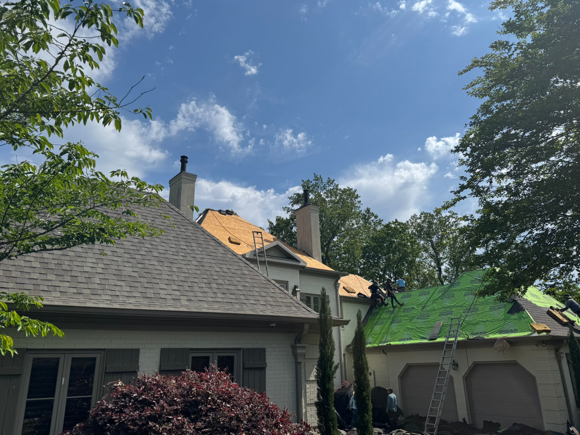 Purple Turtle Roofing crew working through a roof restoration on a two-story home